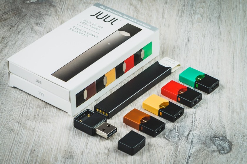 Vaping JUUL Starter kit that comes with the JUUL, a charger, and 4 flavor pods.
